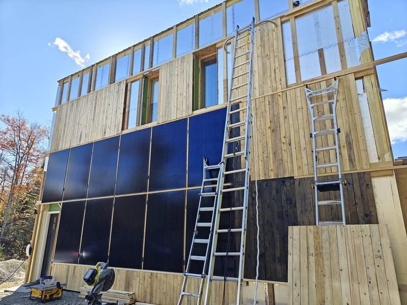 Light wood cladding on Just Haus Alpha, with scaffolding at one corner.